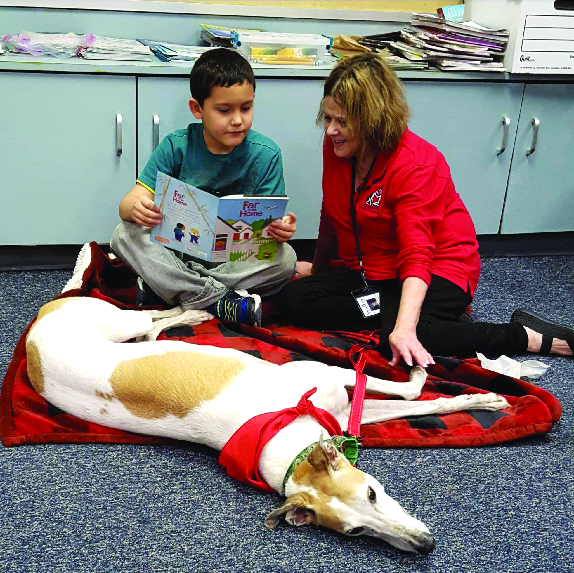 Photograph of a child reading with a therapy dog team (R.E.A.D. Program)