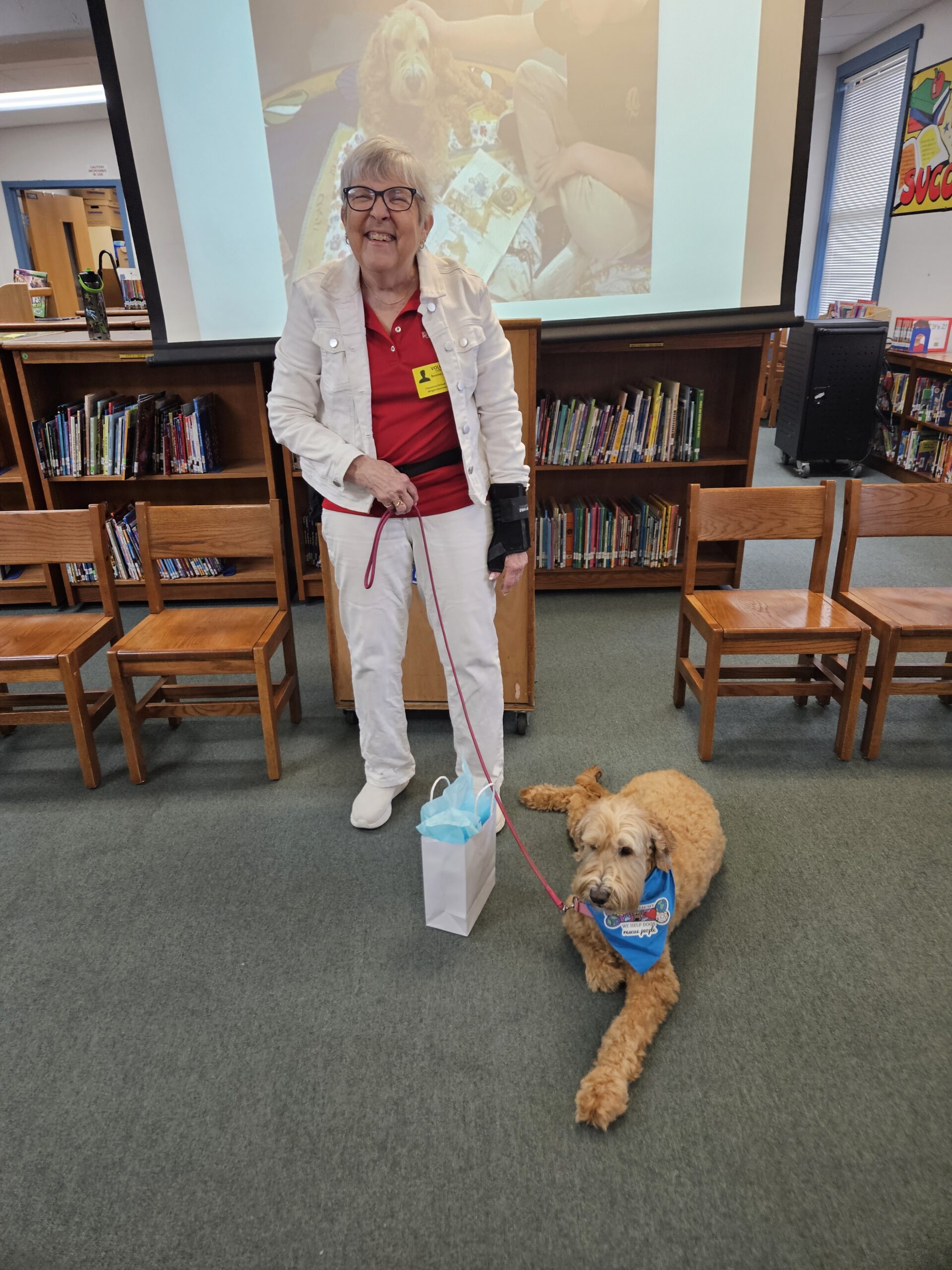 photograph of bonnie london with her reading paws therapy dog, scout, at an okaloosa county, florida school